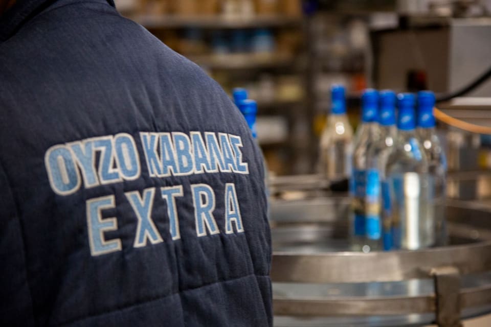Εργαζόμενη με γιλέκο «Ούζο Καβάλας EXTRA» στη γραμμή εμφιάλωσης